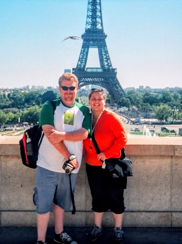 Couple standing in front of the Eiffel Tower in Paris France