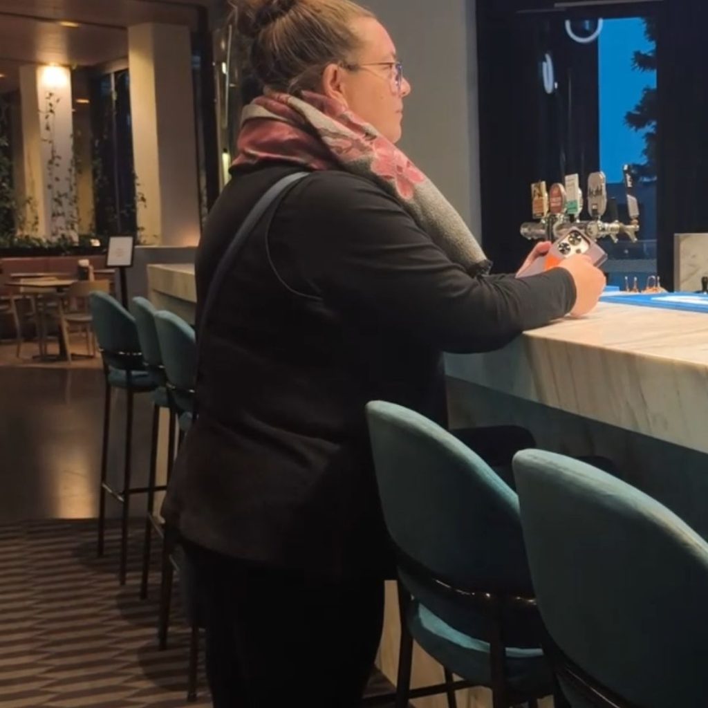Bec ordering a drink at happy hour at the Vibe Hotel Docklands bar off the check in lobby